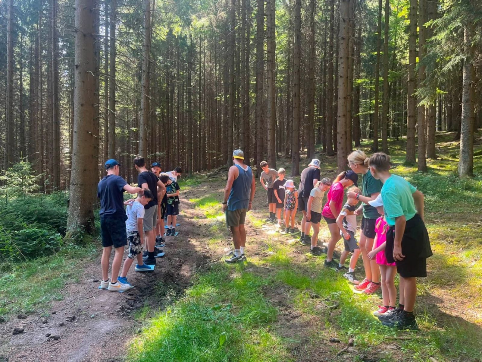 Děti a lektoři při hře v šumavském smrkovém lese